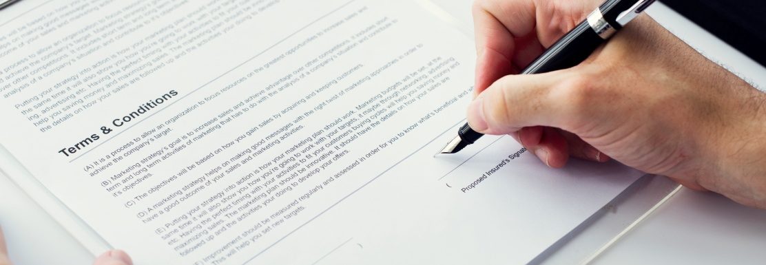 Closeup of hand signing paper workspace